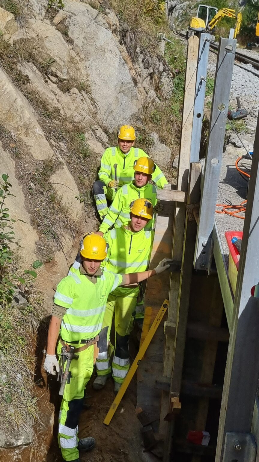 Notter Lehrlinge (Gruppenfoto) bei der Sanierung des Bahn-Brücken-Fundaments der Dampfbahn Furka-Bergstrecke